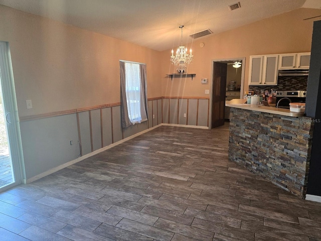 113 Guava Ter, Ocklawaha, FL 32179 - kitchen featuring stainless steel range oven, a chandelier, under cabinet range hood, dark wood finished floors, and lofted ceiling