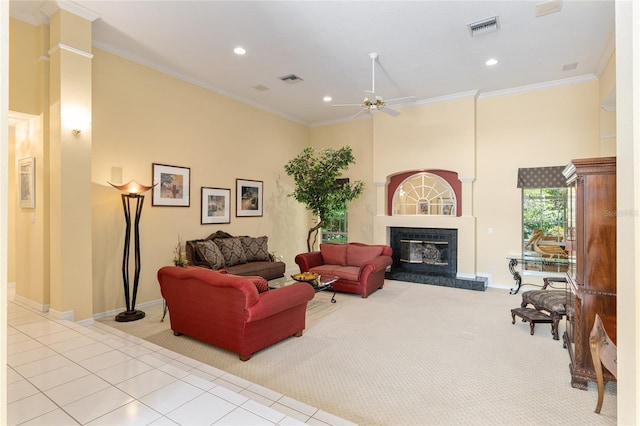 living room with light tile patterned floors, ceiling fan, ornamental molding, and a premium fireplace