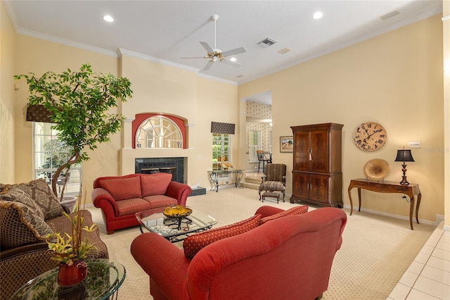 living room featuring ceiling fan, light tile patterned floors, and crown molding