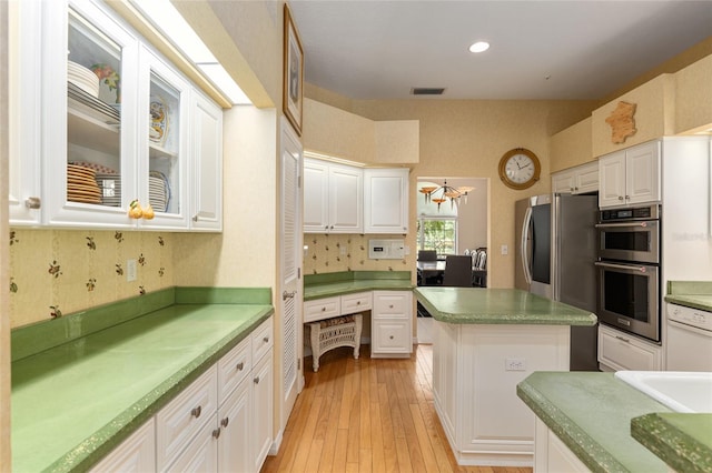 kitchen with tasteful backsplash, stainless steel appliances, a chandelier, light hardwood / wood-style floors, and white cabinetry