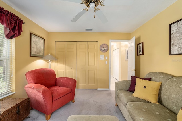 carpeted living room with ceiling fan