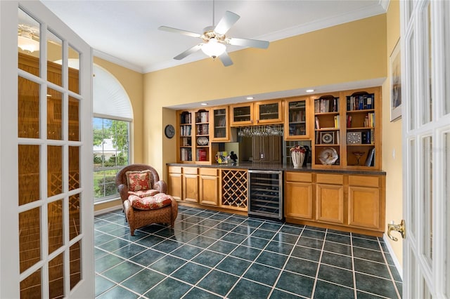 bar featuring wine cooler, ceiling fan, dark tile patterned flooring, and ornamental molding