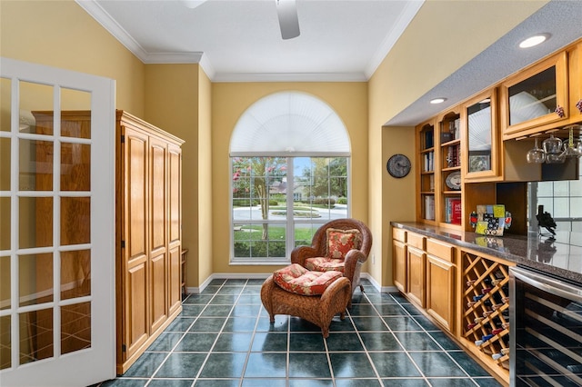 sitting room with dark tile patterned flooring, wine cooler, bar, and crown molding