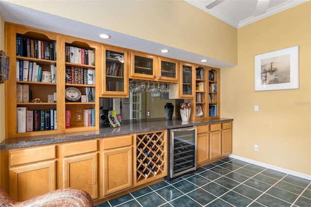 bar with wine cooler, crown molding, ceiling fan, and dark tile patterned flooring