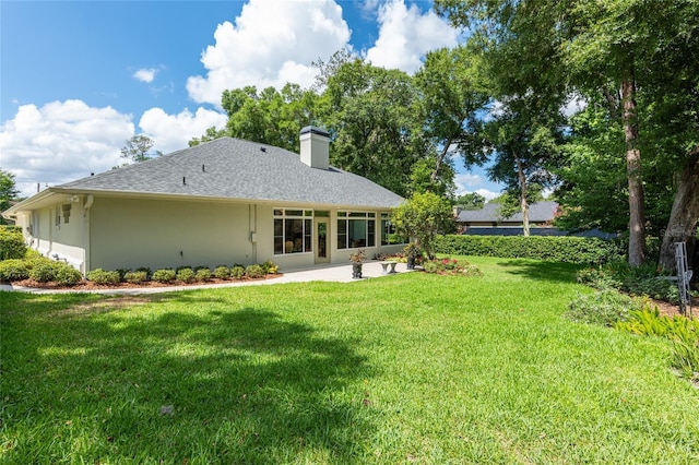 rear view of house featuring a patio area and a yard