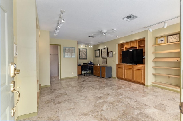 unfurnished living room with a textured ceiling, built in features, and ceiling fan