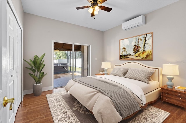 bedroom with ceiling fan, dark wood-type flooring, a wall unit AC, access to outside, and a closet