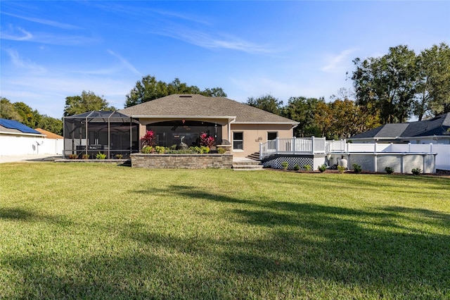 back of property with ceiling fan, a pool side deck, and a lawn