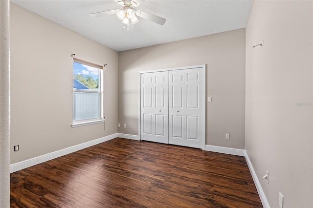 unfurnished bedroom with ceiling fan, dark hardwood / wood-style floors, and a closet