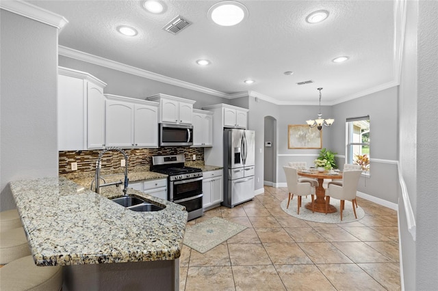 kitchen featuring decorative backsplash, ornamental molding, stainless steel appliances, sink, and white cabinets