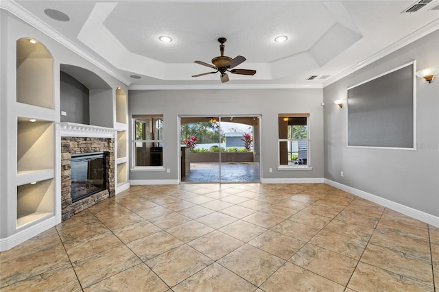 unfurnished living room featuring ceiling fan, built in features, and a tray ceiling