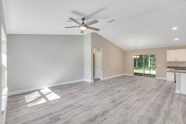 unfurnished living room with ceiling fan with notable chandelier, light hardwood / wood-style floors, and vaulted ceiling