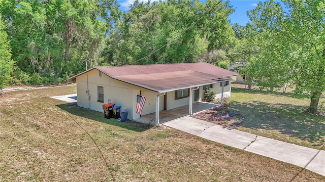 5507 SE 107th Pl, Belleview, FL 34420 - view of side of home with concrete driveway, a carport, a yard, and a shingled roof
