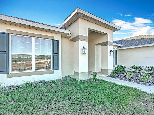 doorway to property with a lawn