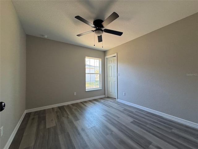 unfurnished room with dark hardwood / wood-style floors, ceiling fan, and a textured ceiling