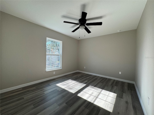 spare room with dark hardwood / wood-style flooring and ceiling fan