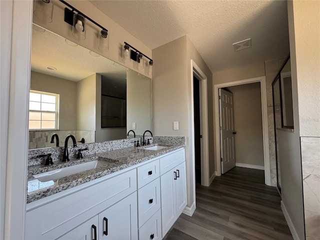 bathroom featuring hardwood / wood-style floors, vanity, and a textured ceiling