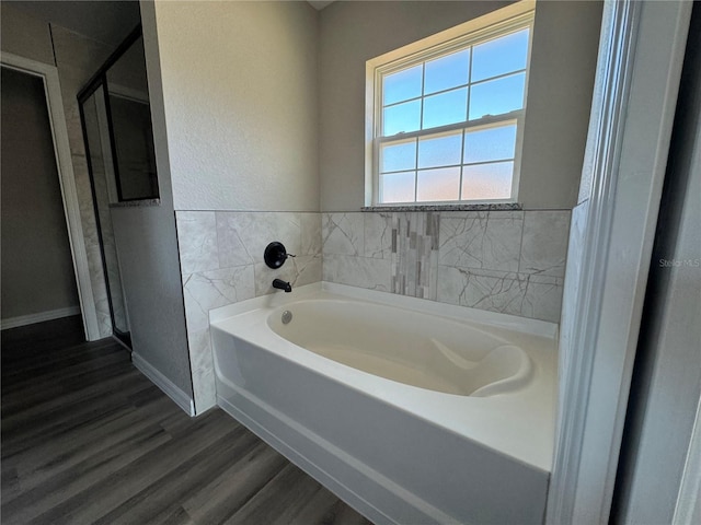 bathroom with a bath and wood-type flooring