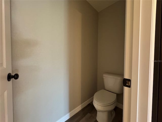 bathroom featuring lofted ceiling, toilet, and wood-type flooring