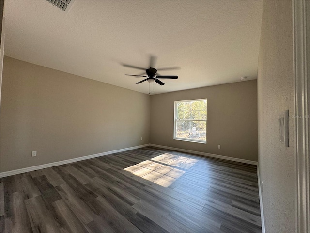 empty room with a textured ceiling, dark hardwood / wood-style floors, and ceiling fan