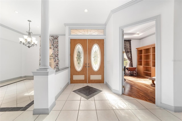 foyer featuring crown molding, french doors, light tile patterned floors, and a notable chandelier