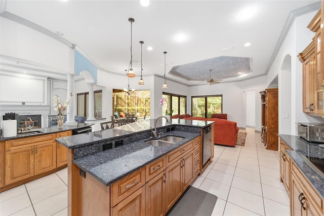 kitchen featuring ceiling fan, sink, decorative light fixtures, dishwasher, and an island with sink