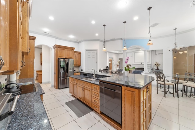 kitchen featuring sink, hanging light fixtures, stainless steel appliances, a kitchen island with sink, and light tile patterned floors