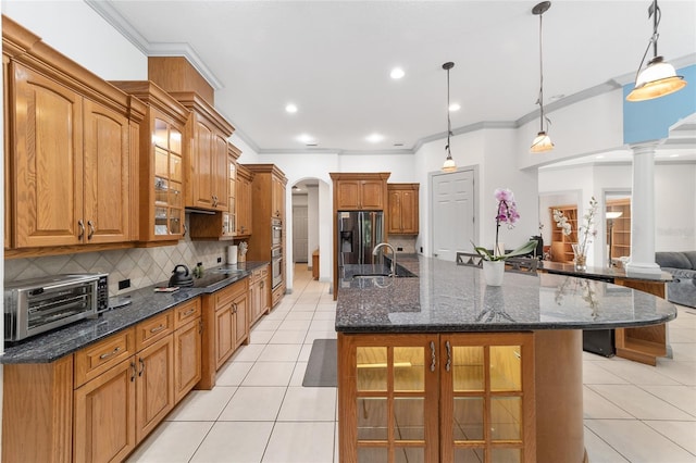 kitchen with decorative backsplash, decorative columns, stainless steel appliances, a spacious island, and pendant lighting