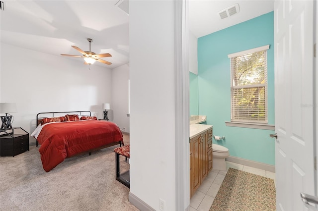 tiled bedroom with connected bathroom and ceiling fan