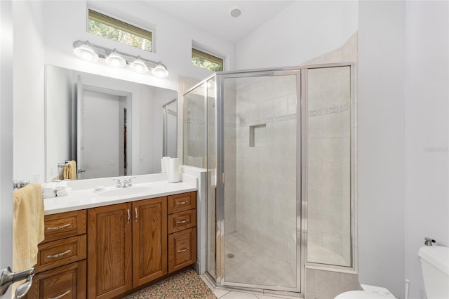 bathroom featuring tile patterned floors, vanity, an enclosed shower, and toilet