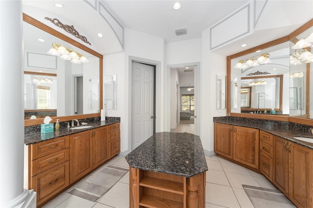 bathroom featuring decorative columns, a wealth of natural light, tile patterned flooring, and vanity