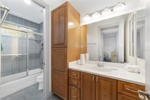 full bathroom with shower / bath combination with glass door, tile patterned floors, vanity, and toilet