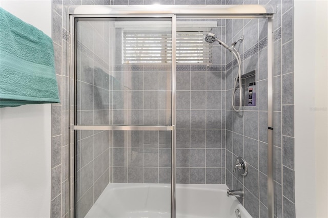 bathroom with bath / shower combo with glass door