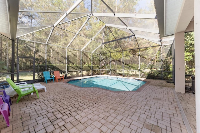 view of pool featuring glass enclosure and a patio area