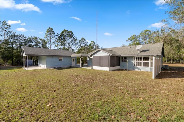 rear view of house featuring central AC, a carport, a lawn, and a sunroom