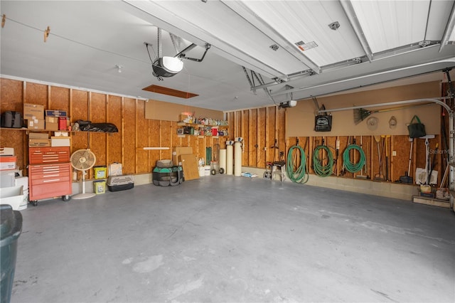 garage with a garage door opener and wood walls