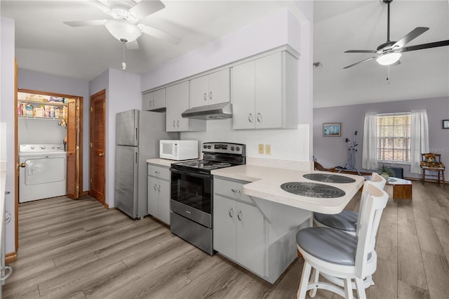 kitchen featuring stainless steel refrigerator, tasteful backsplash, black electric range, kitchen peninsula, and washer / dryer