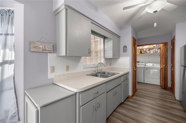 kitchen with backsplash, separate washer and dryer, ceiling fan, and sink