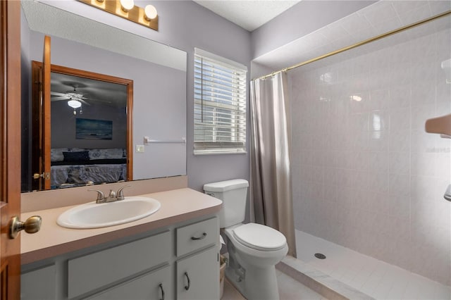 bathroom featuring ceiling fan, vanity, a shower with shower curtain, and toilet