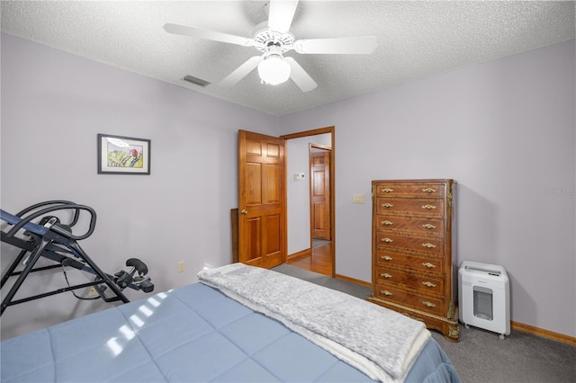 carpeted bedroom with ceiling fan and a textured ceiling