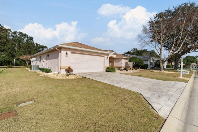 view of front of property with central AC, a garage, and a front lawn