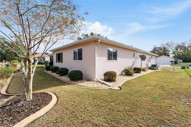 view of home's exterior featuring a lawn, central AC unit, and a garage