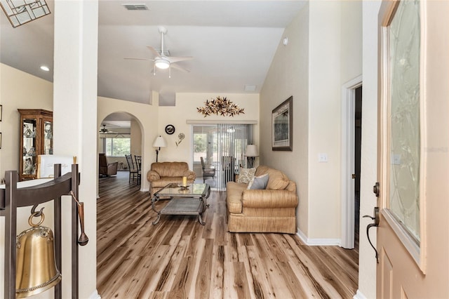 living room featuring ceiling fan, lofted ceiling, and light wood-type flooring