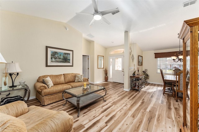 living room with ceiling fan with notable chandelier, light hardwood / wood-style floors, plenty of natural light, and lofted ceiling