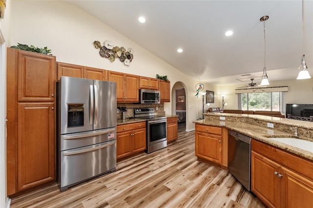 kitchen with pendant lighting, ceiling fan, appliances with stainless steel finishes, tasteful backsplash, and light stone counters