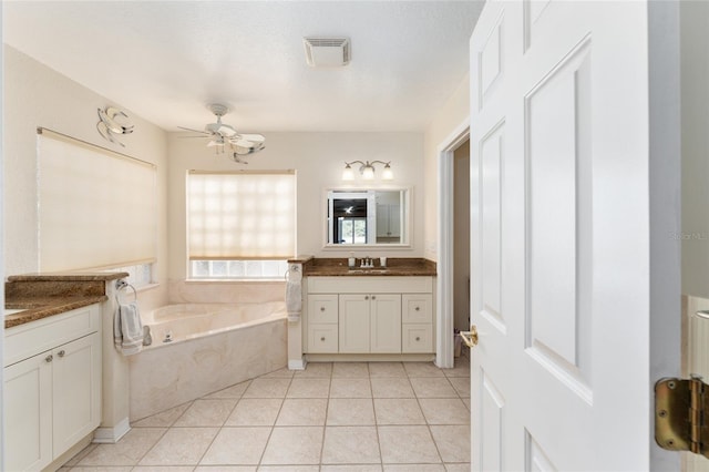 bathroom featuring tile patterned floors, a bathtub, a textured ceiling, vanity, and ceiling fan