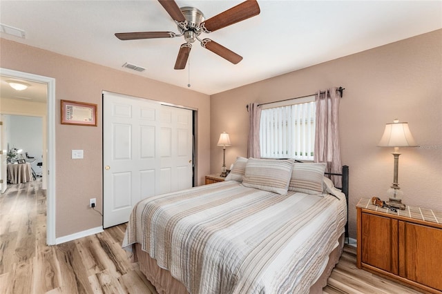 bedroom featuring light wood-type flooring, a closet, and ceiling fan