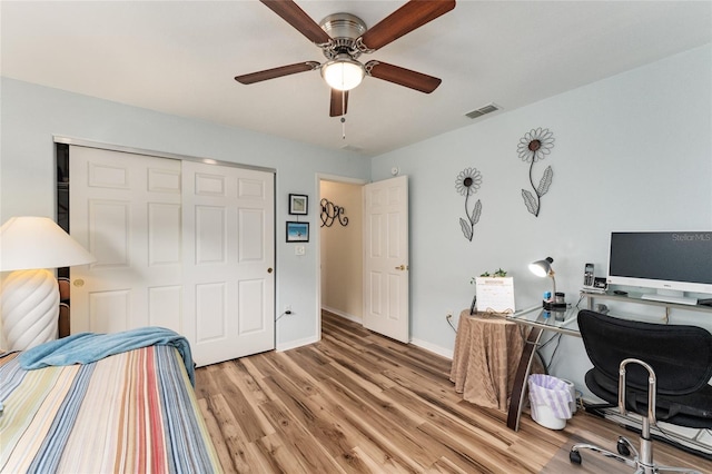 bedroom featuring ceiling fan, light hardwood / wood-style flooring, and a closet