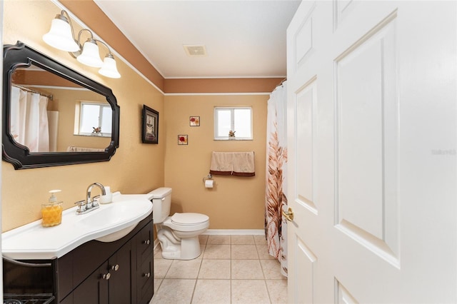 bathroom with tile patterned floors, a wealth of natural light, vanity, and toilet