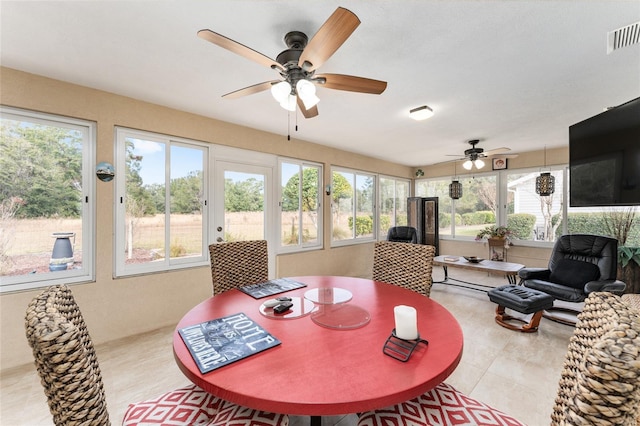 tiled dining room featuring plenty of natural light and ceiling fan